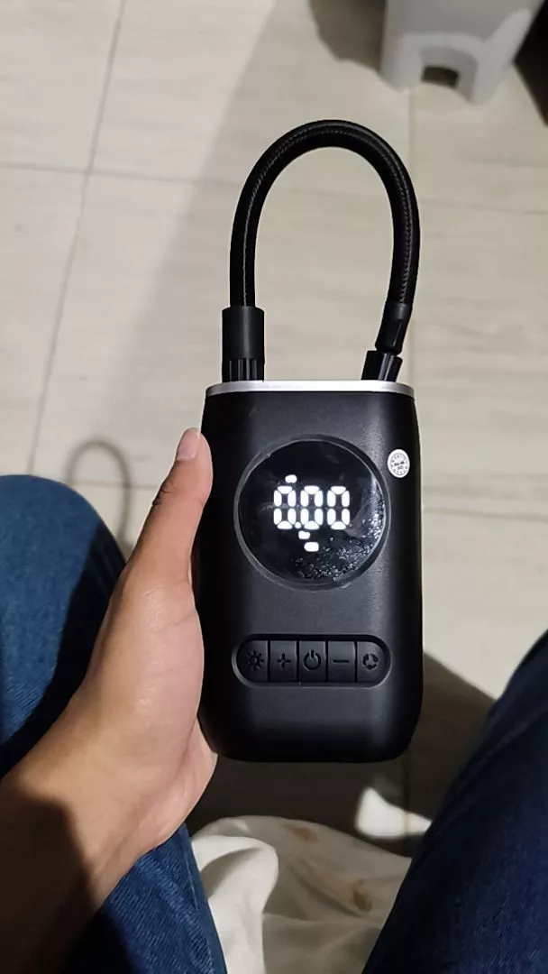 Cliente segurando o mini compressor de ar digital ligado